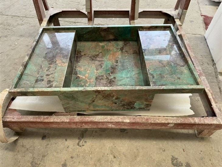 Rear workshop view of an Amazonite Quartzite countertop with an integrated stone sink and raised side surfaces.