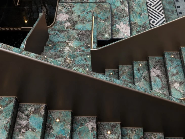 Amazonite Quartzite interior staircase with polished stone treads, integrated step lighting and dark side panels