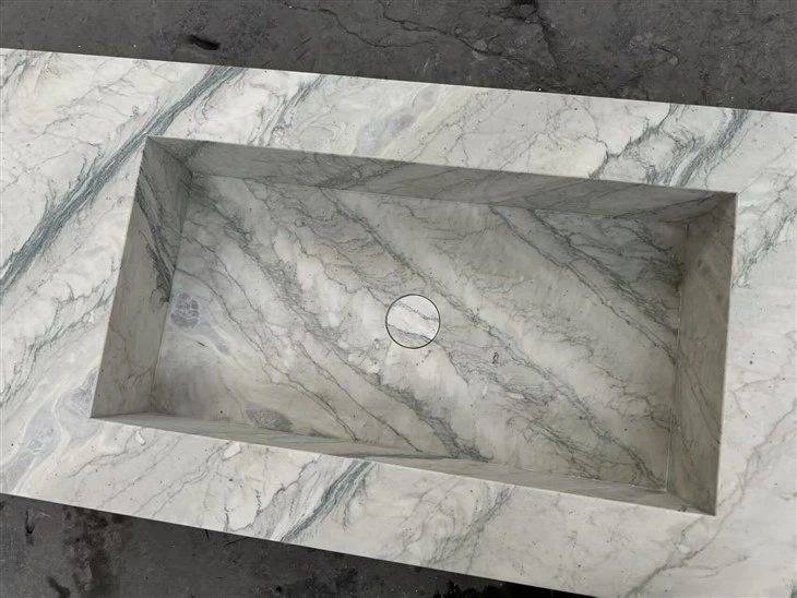 Close view of the fabricated Luce Di Luna Quartzite integrated sink, showing mitered internal corners and the drain opening.