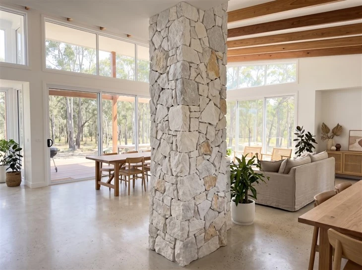Natural White Quartzite loose random stone wall cladding installed on a floor-to-ceiling square column in a contemporary open-plan living space
