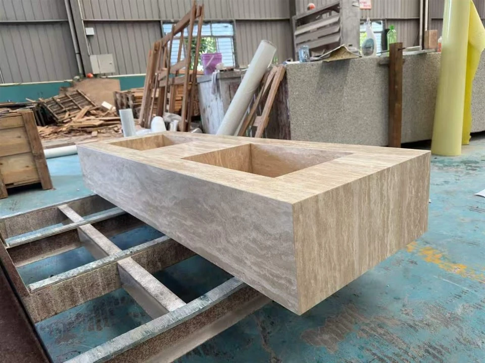 Angled factory view of a finished Classic Beige Travertine countertop with two integrated rectangular sinks.
