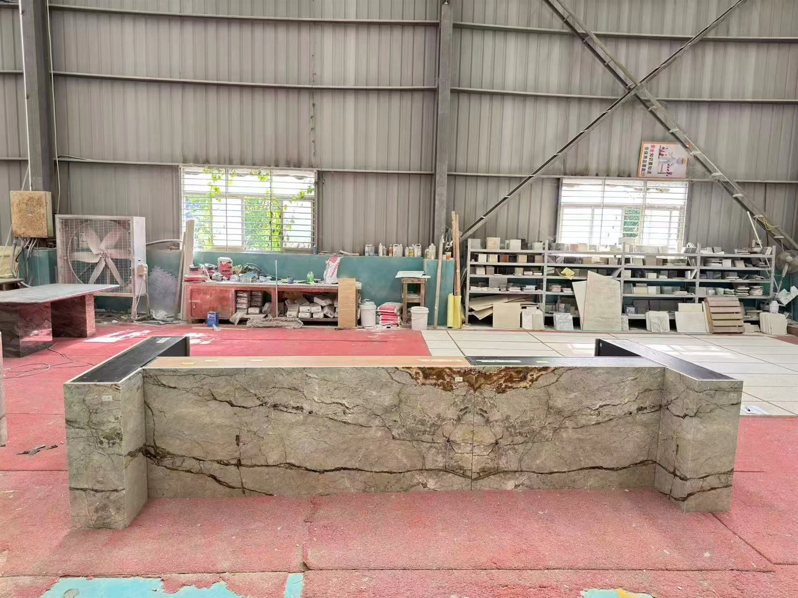 Full factory view of the straight side of a kitchen island clad with Silver Roots Marble panels. Full factory view of the straight side of a kitchen island clad with Silver Roots Marble panels.