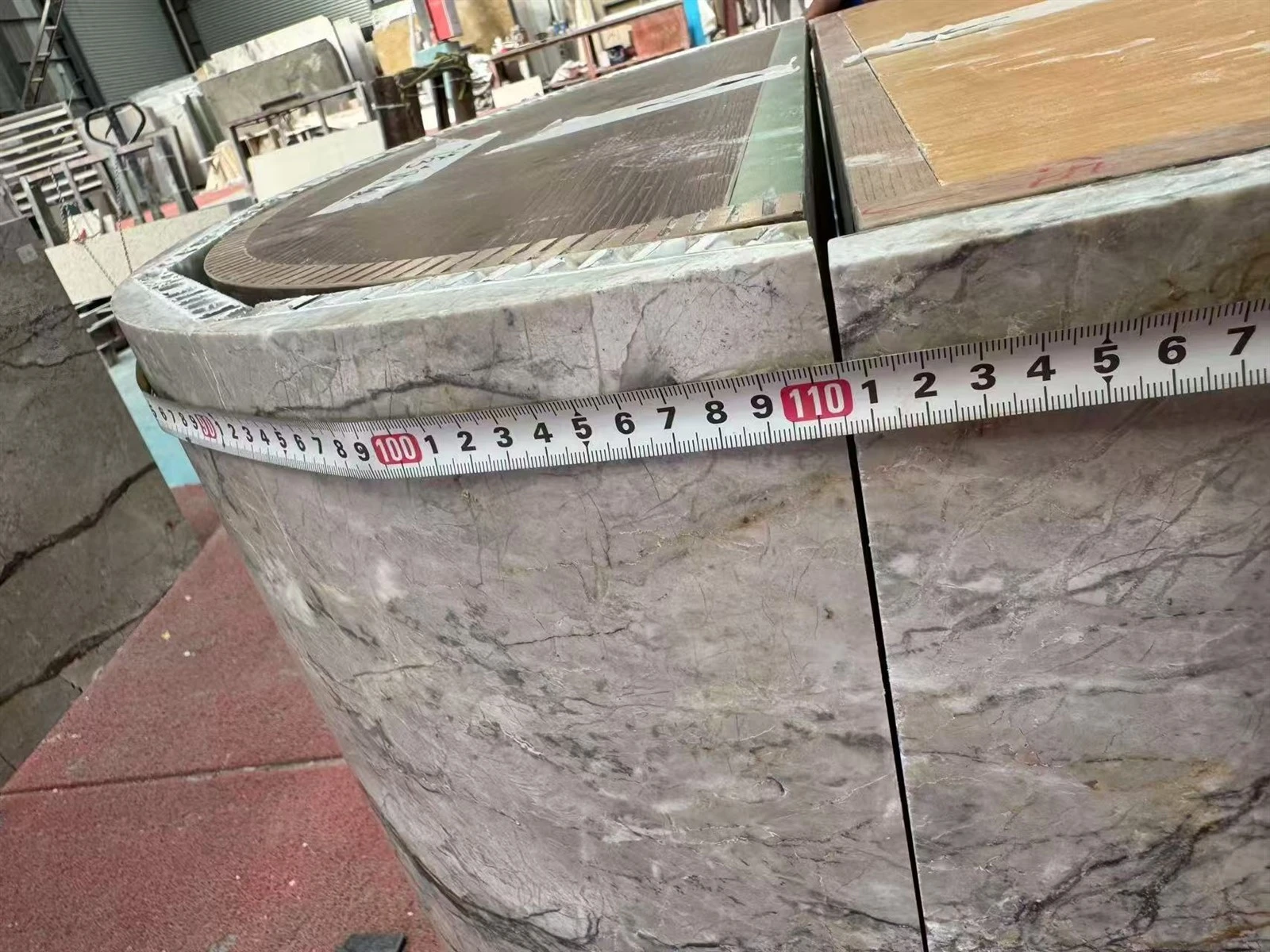 Close-up measurement of Silver Roots Marble panels fitted around the curved end of a kitchen island cabinet. Close-up measurement of Silver Roots Marble panels fitted around the curved end of a kitchen island cabinet.