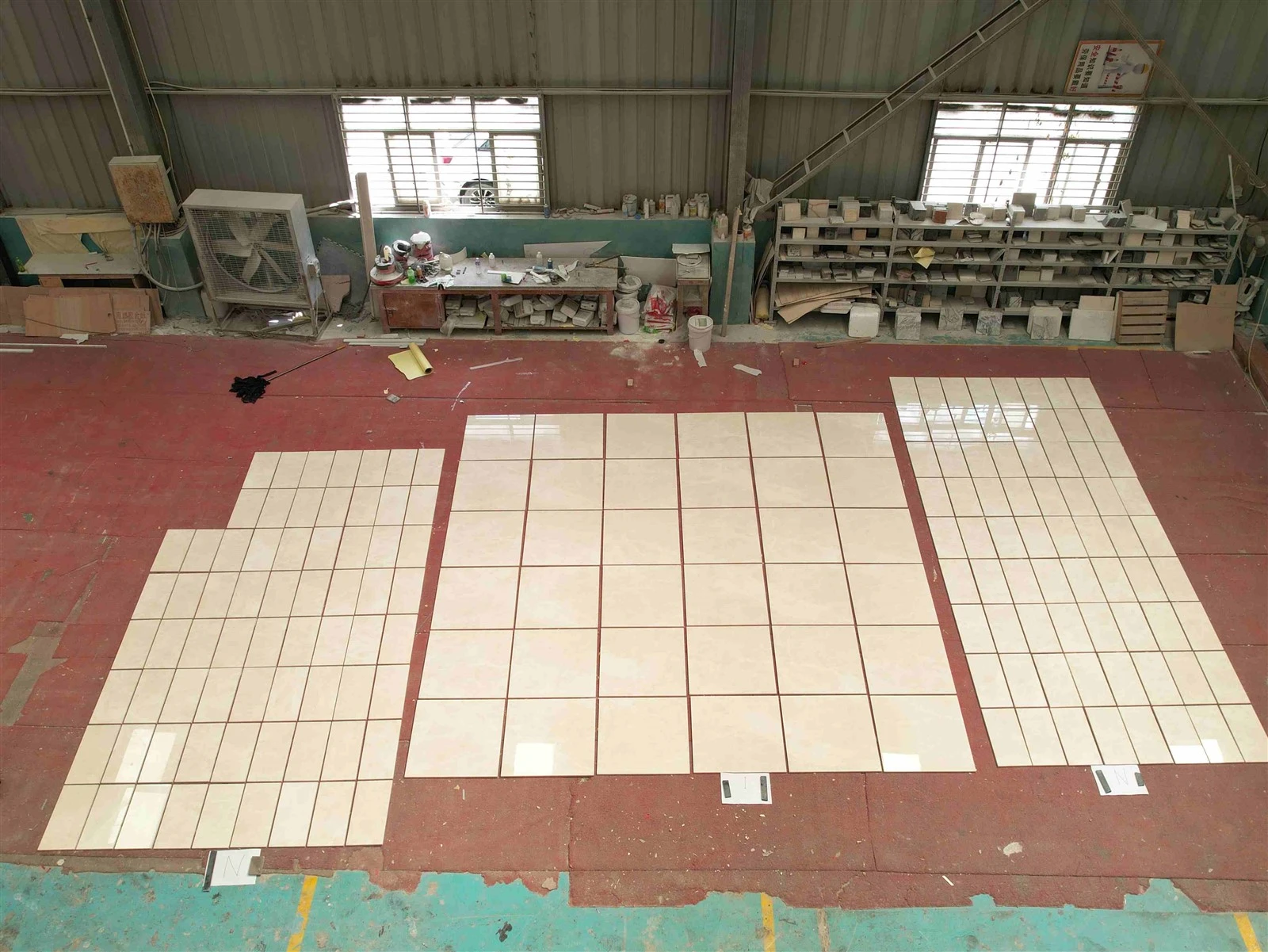 Overhead factory view of multiple wall elevations dry laid in separate groups using polished Aran White Marble tiles. Overhead factory view of multiple wall elevations dry laid in separate groups using polished Aran White Marble tiles.