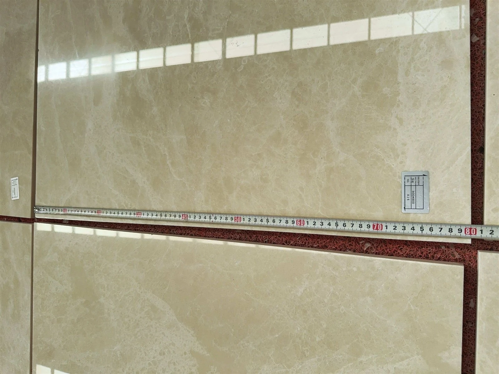 Close-up size inspection of an 800 x 800 mm polished Aran White Marble wall tile marked A14. Close-up size inspection of an 800 x 800 mm polished Aran White Marble wall tile marked A14.