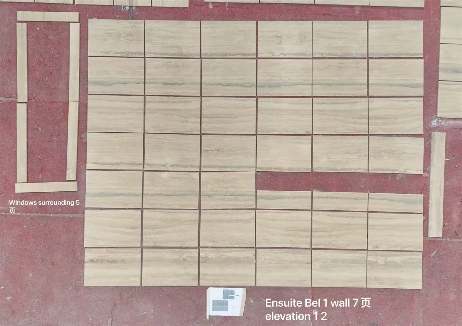 Factory dry layout of cut silver travertine wall tiles and window surrounds for pattern, quality and installation-sequence review. Factory dry layout of cut silver travertine wall tiles and window surrounds for pattern, quality and installation-sequence review.