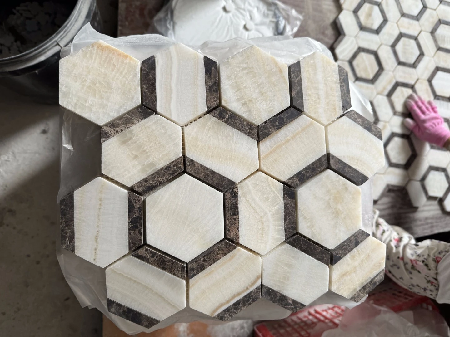 Close-up of one polished 10 mm Vanilla Onyx and Emperador Dark Marble mixed mosaic sheet showing pale onyx fields and dark brown marble accents. Close-up of one polished 10 mm Vanilla Onyx and Emperador Dark Marble mixed mosaic sheet showing pale onyx fields and dark brown marble accents.