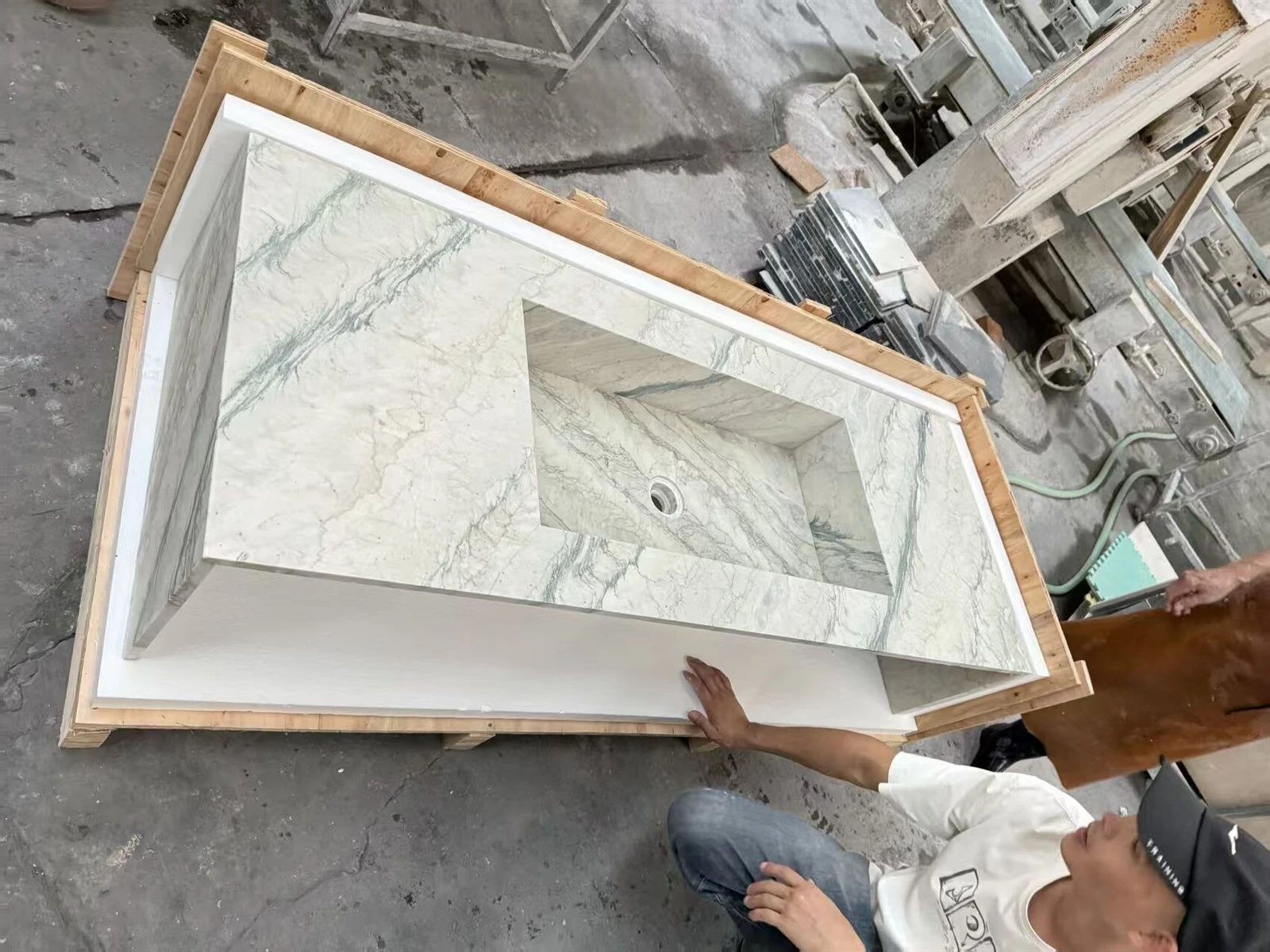 Finished Luce Di Luna Quartzite countertop with integrated sink positioned in a custom foam-lined wooden crate for inspection. Finished Luce Di Luna Quartzite countertop with integrated sink positioned in a custom foam-lined wooden crate for inspection.