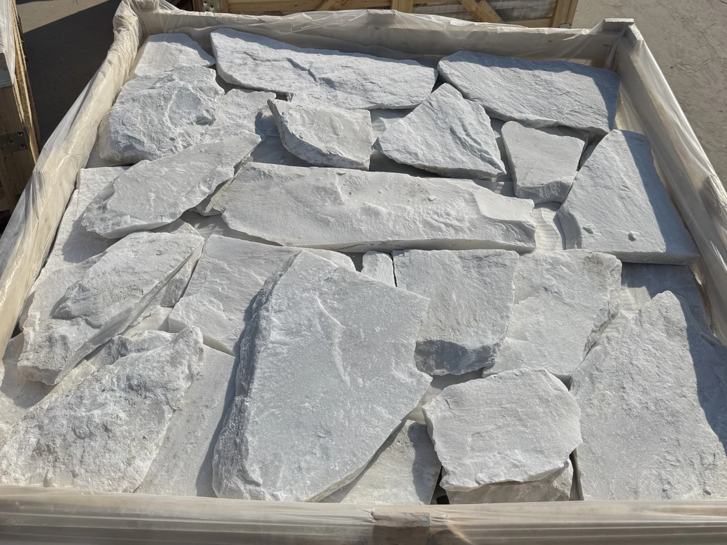 Natural White Quartzite loose random stone wall cladding pieces arranged in a protective wooden crate for packing Natural White Quartzite loose random stone wall cladding pieces arranged in a protective wooden crate for packing