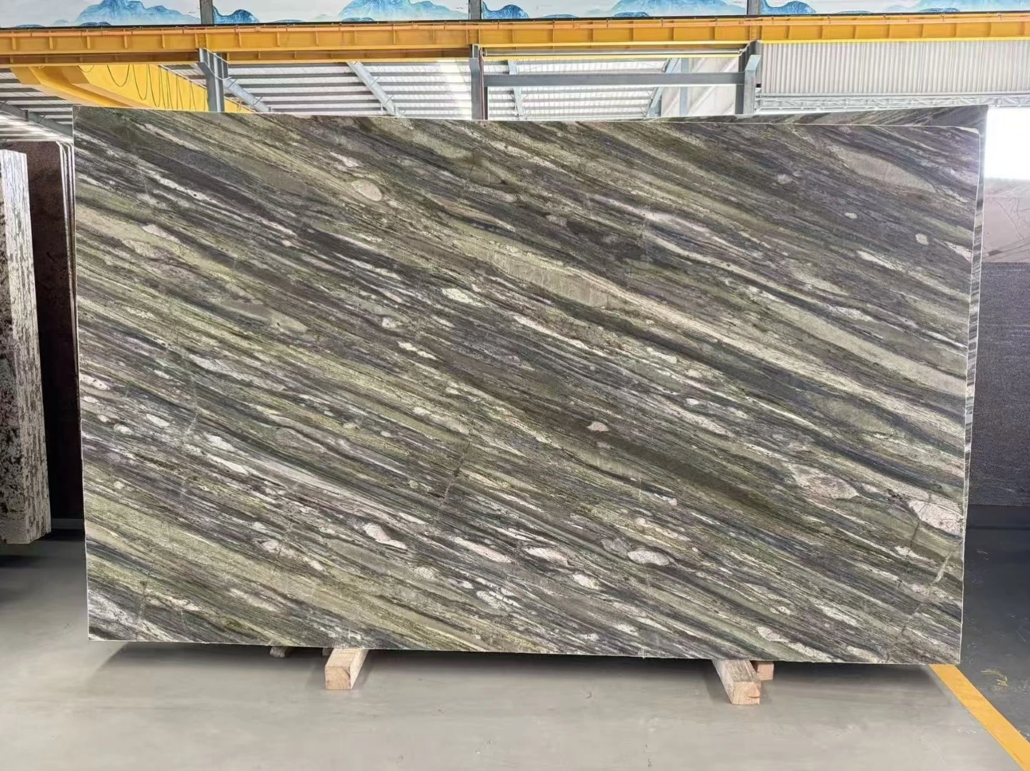 Honed Tropical Fashion Granite slab with flowing green, gray and cream veining displayed in Landiview Stone factory Honed Tropical Fashion Granite slab with flowing green, gray and cream veining displayed in Landiview Stone factory