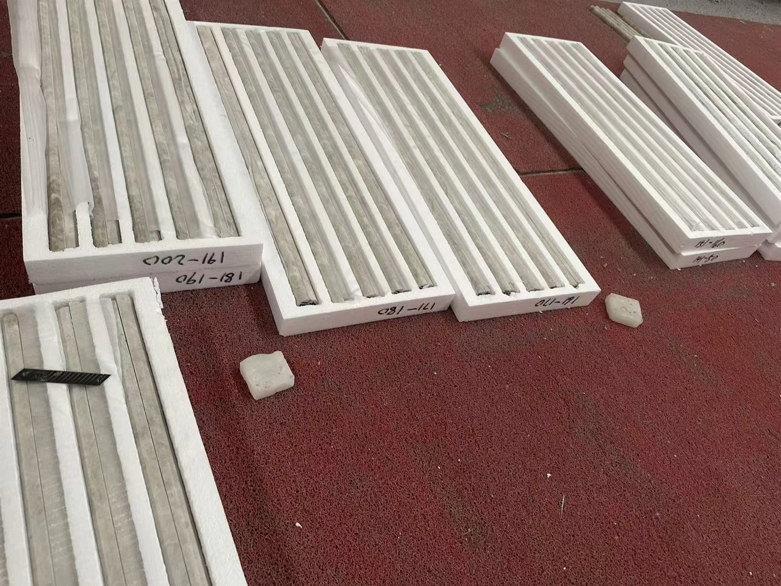 Finished Taj Mahal Quartzite long fluted tiles separated and protected in custom grooved foam trays Finished Taj Mahal Quartzite long fluted tiles separated and protected in custom grooved foam trays