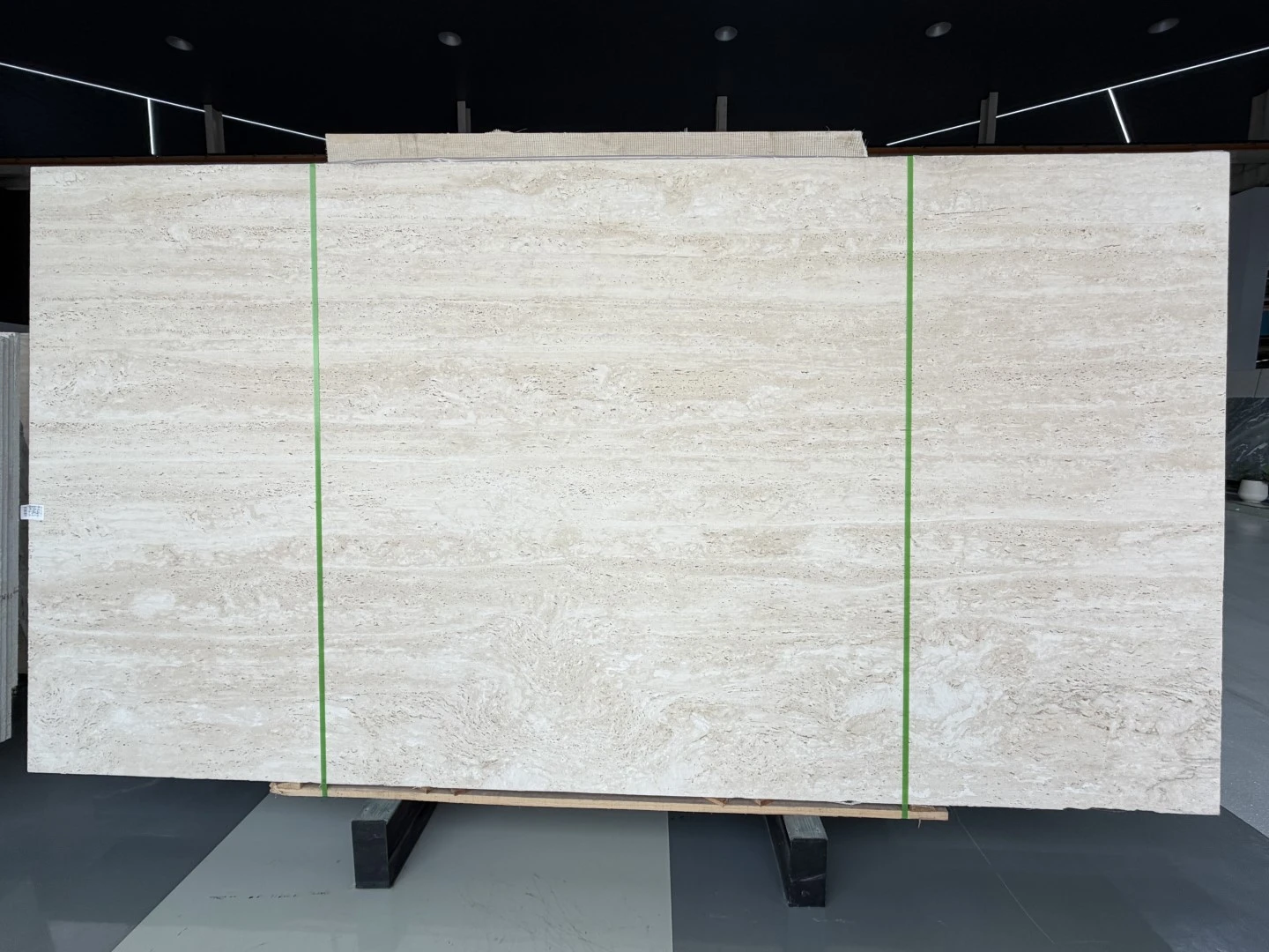 vein-cut Navona Travertine slab with a light ivory background, subtle horizontal movement and natural porous texture displayed in Landiview Stone showroom vein-cut Navona Travertine slab with a light ivory background, subtle horizontal movement and natural porous texture displayed in Landiview Stone showroom